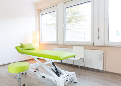 Ein Behandlungszimmer in der Physiotherapie Thomsen und Clauss in Norderstedt mit einer grünen Behandlungsliege und einem passenden Stuhl
