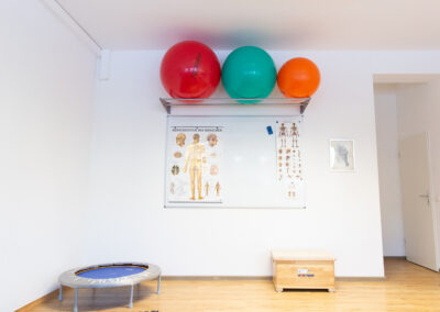Trainingsbereich 1 in der Physiotherapie Thomsen und Clauss in Norderstedt mit einem Trampolin, mehreren Pezzi Bällen und einem Whiteboard